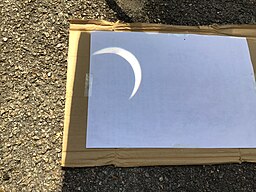 pinhole projection of an eclipse. You see a crescent of light projected on a shadow